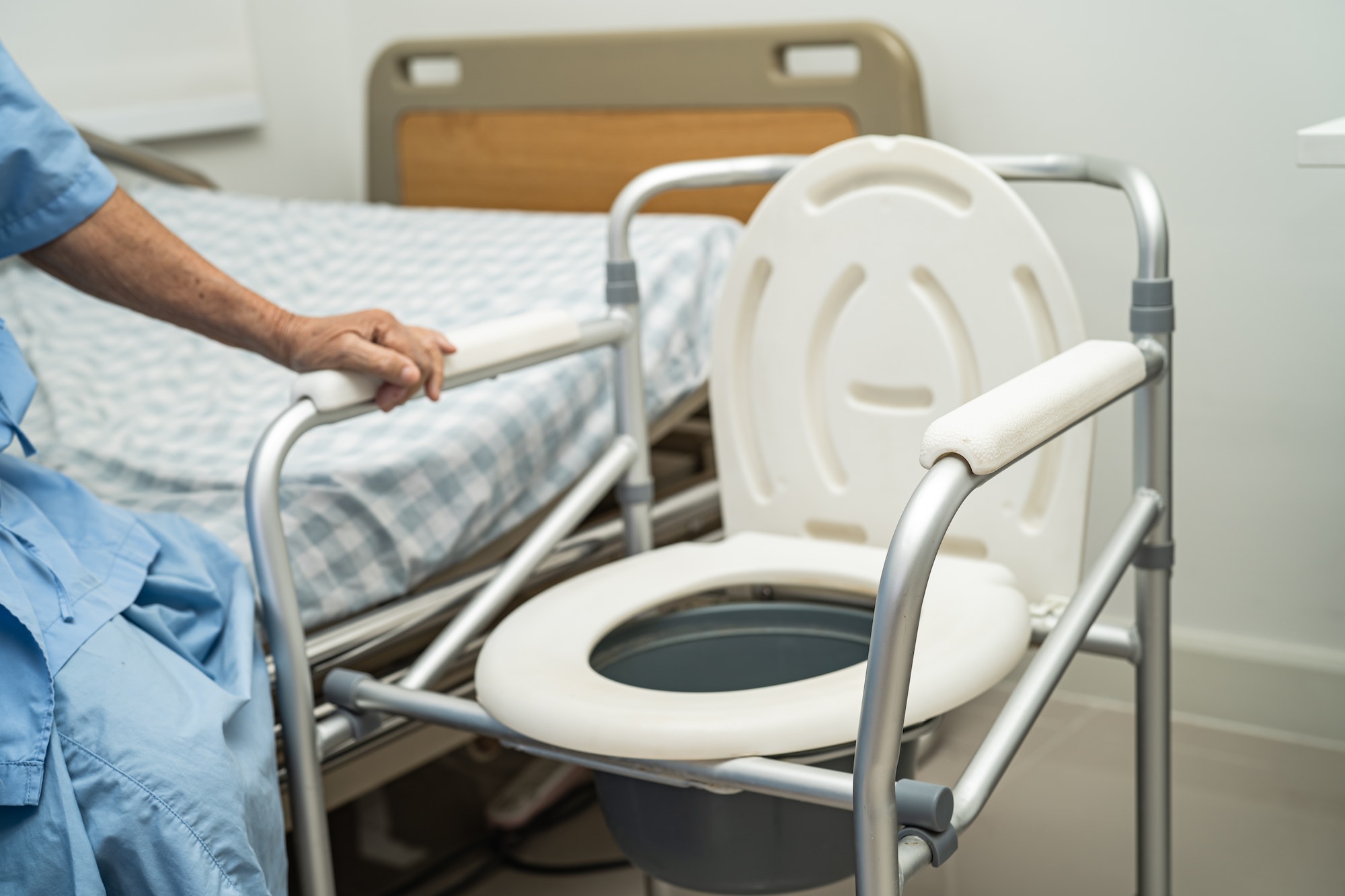 Flush toilet and shower chair in bathroom for old elder people.